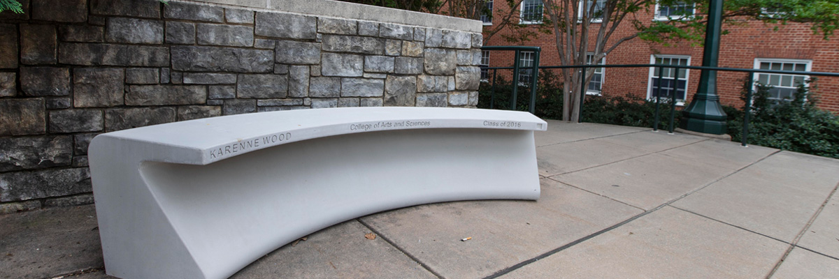 A modern stone bench engraved with the name Karenne Wood
