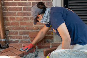 Daisy Maine laying brick and mortar