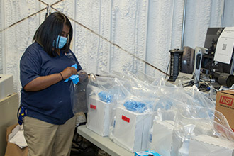An FM employee packing several clear bags of supplies