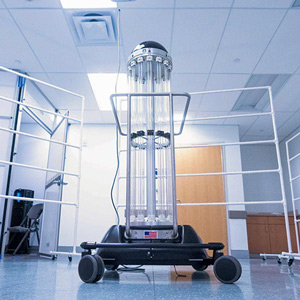 A cylindrical robot on wheels that disinfects personal protective equipment