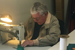 Carl Shifflett using a sewing machine