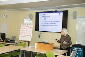 Sandra Smith teaches a course with the assistance of a PowerPoint presentation