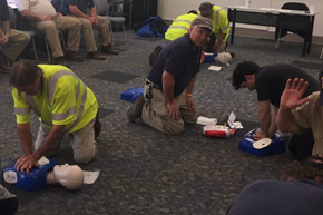 Facilities Management employees practicing CPR on dummies