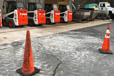 Safety cones and Bobcats parked in a row