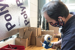 FM employee taping a cardboard box shut