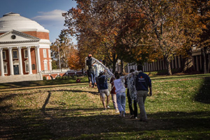 FM staff and volunteers carrying long strings of lights on The Lawn