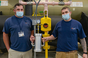 Jonathan Ragland and Dusty Buck holding a vacuum chamber