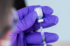 A medical worker administering an injection to someone's arm