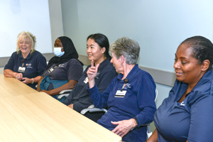 Custodial Services workers talk at a conference table