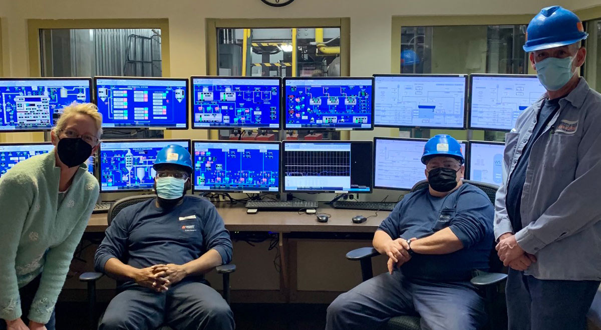 Members of the Heat Plants team sitting in front of an array of monitors