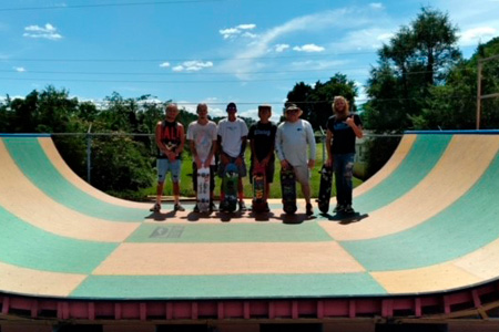 Skateboarders standing in the center of a half-pipe skateboarding ramp