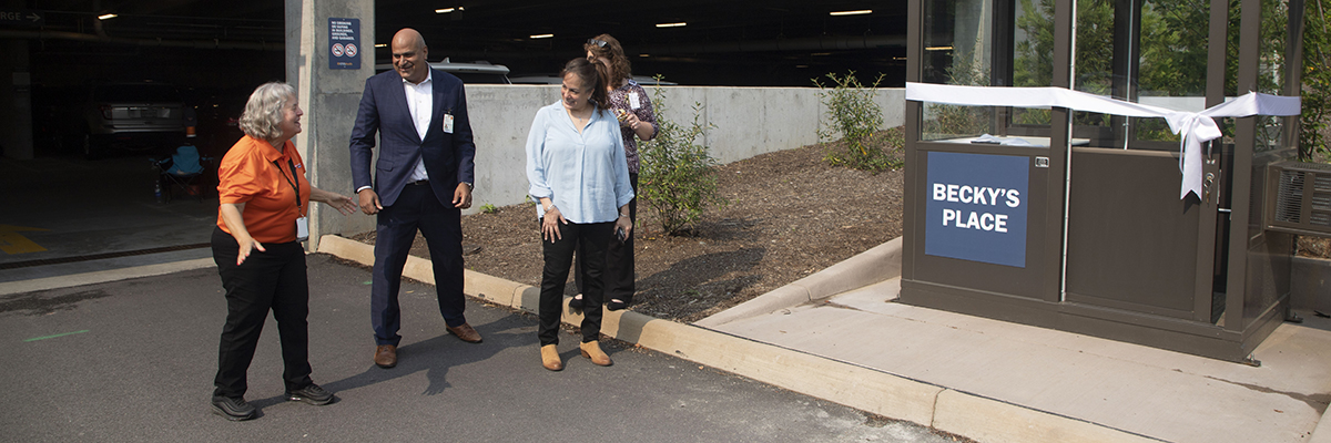 OCIR employees stand next to new parking booth