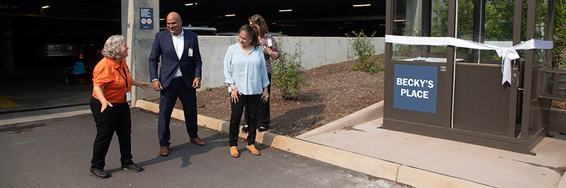 OCIR employees stand next to new parking booth