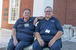 Cheryl Johnson and Kathy Moon sit side-by-side in front of the Rotunda