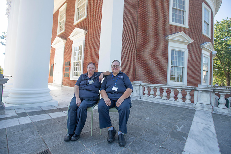 Cheryl Johnson and Kathy Moon sit side-by-side in front of the Rotunda