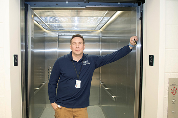 Alex Gavrylenko stands in front of an open elevator