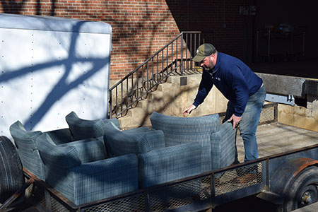 Jason Dalton, of Elk Hill, loads surplus chairs from the UVA ReUSE store