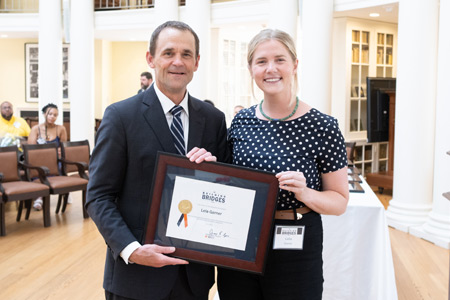 Lela Garner holds an award with President Jim Ryan