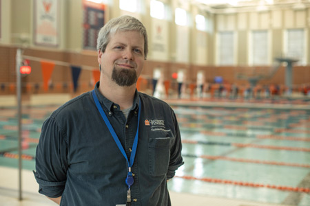 Justin Moore stands in front of an indoor pool