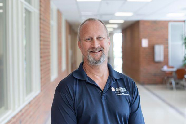 Brian Thomas in a hallway, smiling at the camera