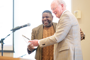 Associate Vice President and Chief Facilities Officer Don Sundgren presents A.J. Young with a plaque recognizing the award.
