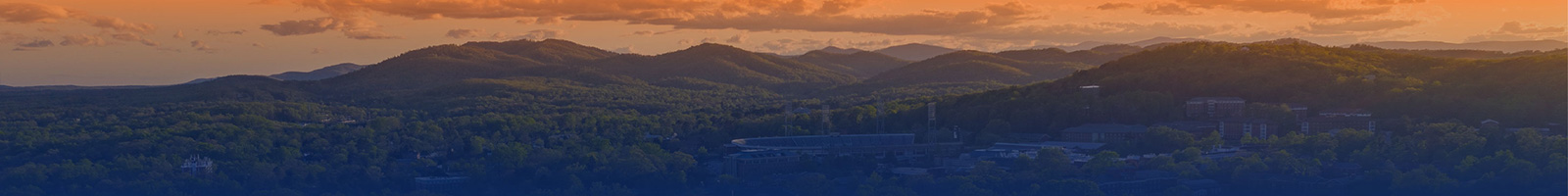 The mountainous skyline west of Charlottesville in a gradient of UVA Orange and Blue