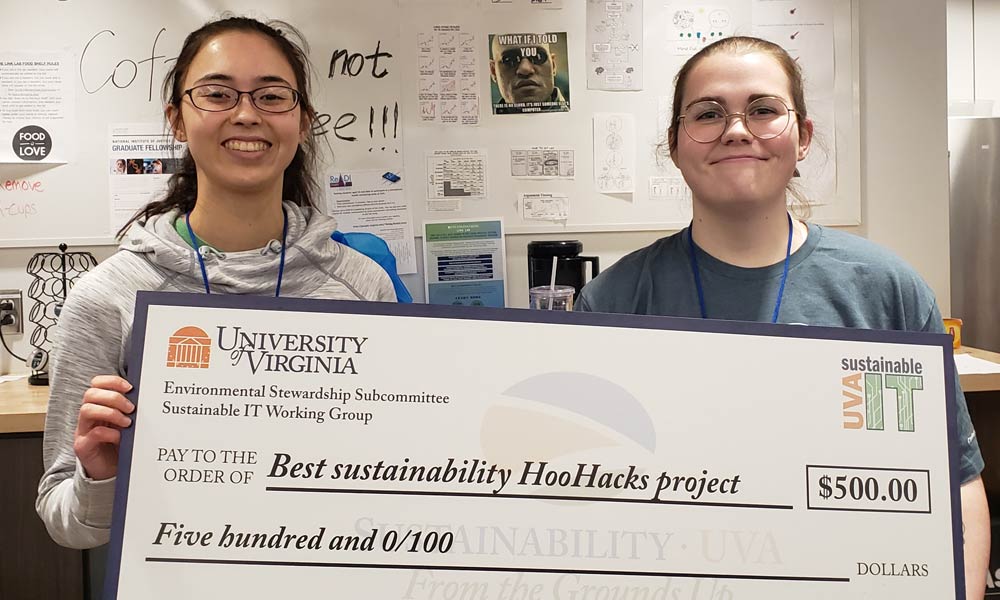 Electrical engineering majors Emily Flynn and Colleen Foley hold an oversized check for 500 dollars, their prize from U.V.A. Sustainable I.T. for best sustainability HooHacks project