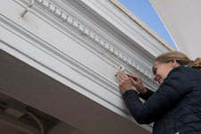 Conservator Susan Buck takes a paint sample from a pavilion in Academical Village