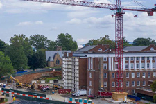 Wide angle view of a construction crane and the renovations in progress on Alderman Library