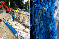 A slab of multiple layers of paint on Beta Bridge being removed by a bucket loader