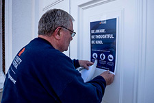 A UVA Facilities Management employee tapes a notice on the door of Old Cabell Hall
