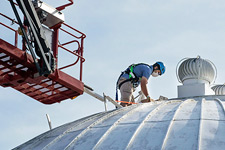 Jimmy Davidson, in fall prevention equipment, works atop the the McCormick Observatory dome