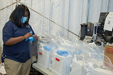 An FM employee packing several clear bags of supplies