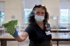 FM employee Sandra Payne disinfects a plexiglass barrier
