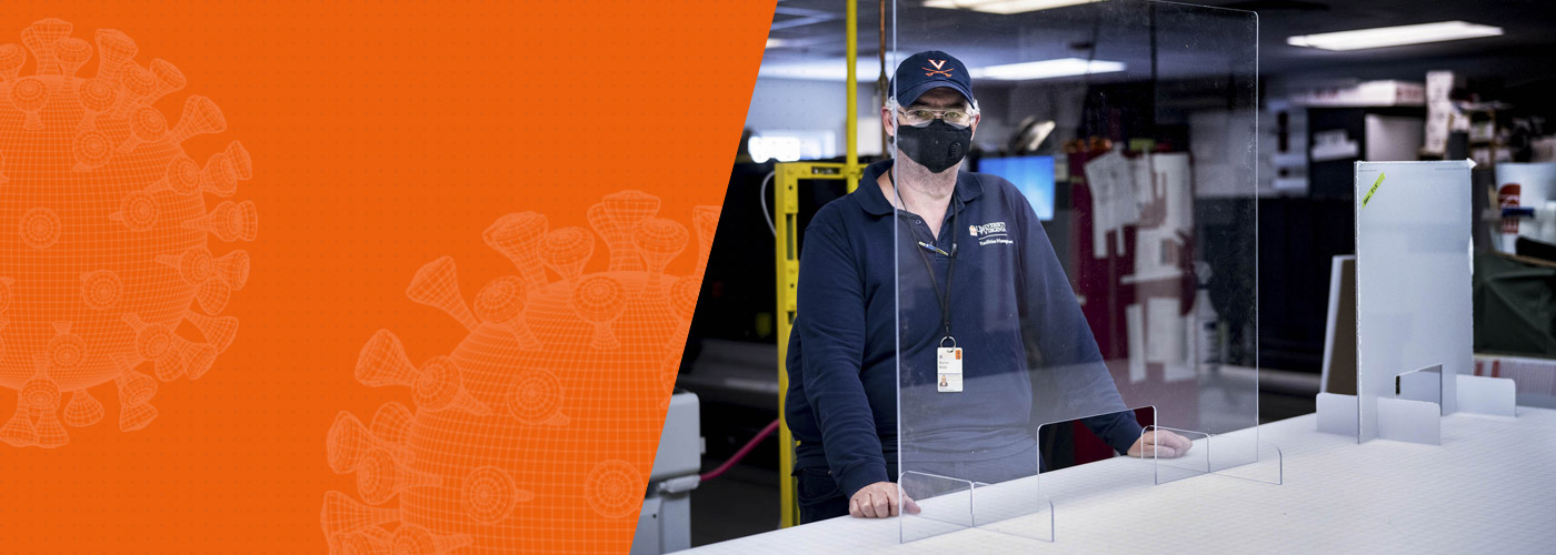 FM employee Warren 'Hubba' Wood stands behind a clear plastic shield in the sign shop