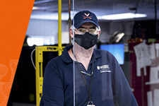 FM employee Warren 'Hubba' Wood stands behind a clear plastic shield in the sign shop