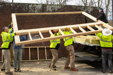 FM employees load assembled sections of a solar kiln onto a truck