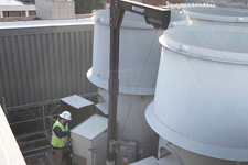 An FM employee services air handlers on the roof of a building