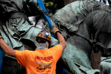 A worker securing straps to the George Rogers Clark statue for removal