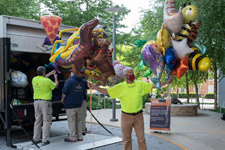 Facilities Management employees offloading graduation balloons from a trailer