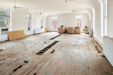 Layers of wood flooring exposed in the Garden Room