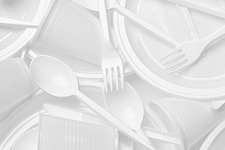 A large pile of white plastic utensils, cups and plates