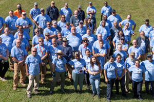 Top-down photo of dozens of FM staff in Day of Caring t-shirts