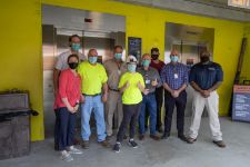 UVA Elevator and Priority Elevator staff posing for a group photo with a young visitor