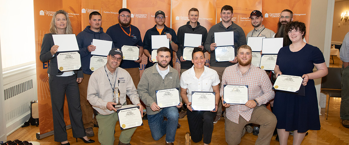 Graduates of UVA's Apprenticeship Program in a group photo holding up their diplomas