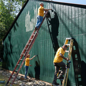 Members of Facilities Management put a fresh coat of paint on a building at Camp Holiday Trails