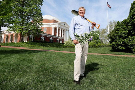 John Sauer holds cut flowers and a small shovel in front of the Rotunda