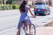 a student cyclist waits to cross the street