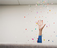 A woman tossing confetti in an office