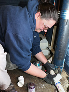 Staff plumber repairing pipes